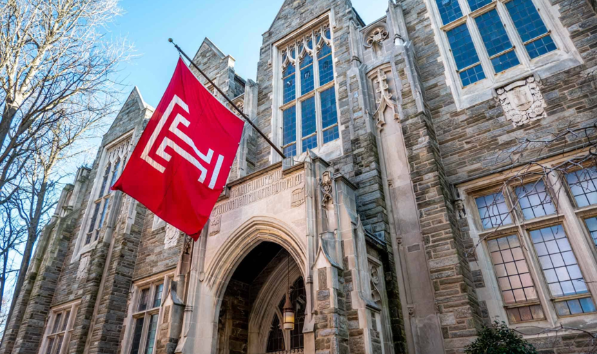 Building at Temple University with red Temple flag hanging outside