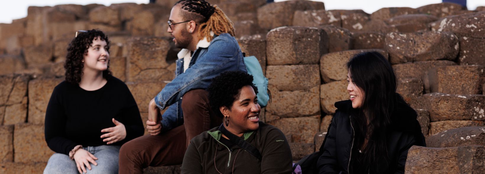 Group photo of Fulbrighters sitting on rocks at Giant's Causeway, Belfast